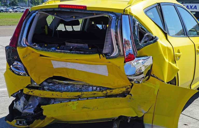 ein gelbes Auto von hinten und es gibt einen totalen Autounfall