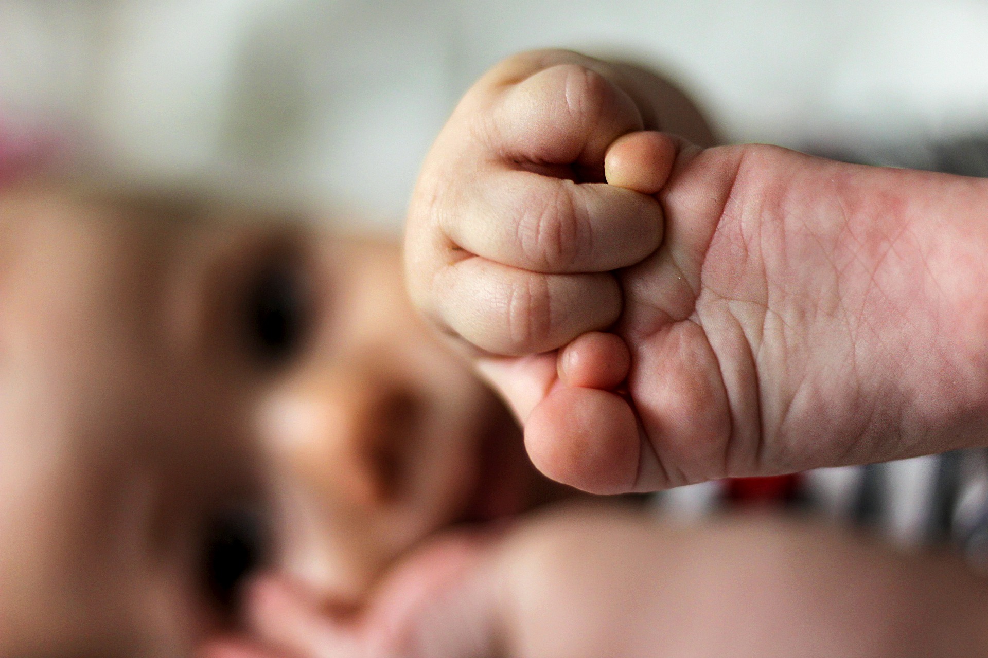 ein Baby hat die Hand am Fuß