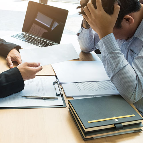 Chef schickt dem Mitarbeiter ein Kündigungsschreiben auf den Tisch im Büro